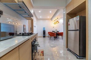 Eine moderne Küche mit Kühlschrank, Spüle und Essbereich mit Stühlen.