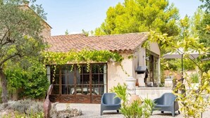 A house with a tiled roof, a large window, and a potted plant in the foreground. - Le clos des lavandes (Lacoste (Provence))
