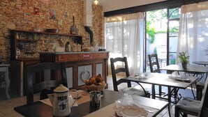 A cozy cafe with stone walls, wooden furniture, and a view of the outdoors. - Le clos des lavandes (Lacoste (Provence))