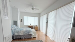 A bedroom with a bed, a ceiling fan, a window with blinds, and a wooden floor. - BEAUTIFUL RENTAL OPEN WATER in Summerland Key (Summerland Key)