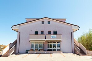 Un immeuble à deux étages, sur lequel on peut lire une enseigne indiquant qu’il s’agit d’un complexe d’appartements.