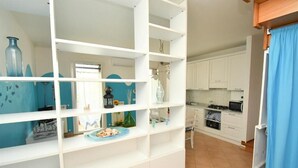 Una cocina con armarios blancos, un microondas y una estufa.