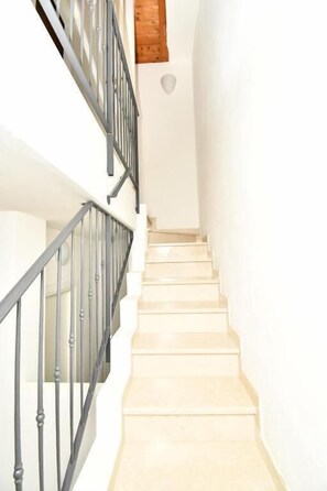 A staircase with a handrail, leading to a landing with a wooden beam ceiling. - Residenz Arcobaleno, Cavalluccio Plus Three-Room Apartment for 6 People (Chioggia)