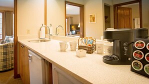 A kitchen with a sink, coffee maker, and coffee pods. - Lake Louise Escape with Private Deck & Views (Lake Louise)