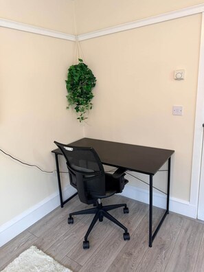 A corner office with a desk, chair, and a hanging plant. - Apartment Opp Leicester Train Station | Central (Leicester)