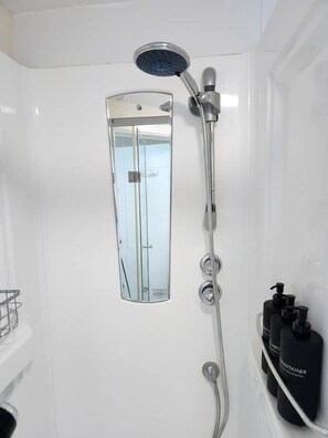 A modern bathroom with a glass-enclosed shower, a handheld showerhead, and a wall-mounted faucet. - Apartment Opp Leicester Train Station | Central (Leicester)