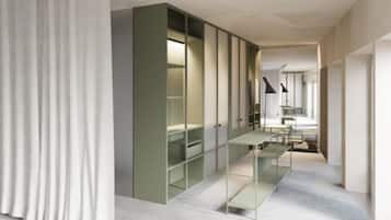 Une chambre d’hôtel moderne équipée d’une armoire intégrée, d’un bureau et d’une chaise.