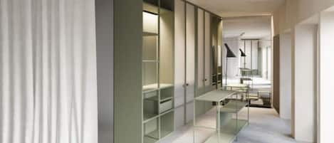 A modern hotel room with a built-in wardrobe, a desk, and a chair.
