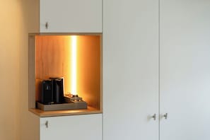 A cabinet with a built-in coffee machine and a shelf.