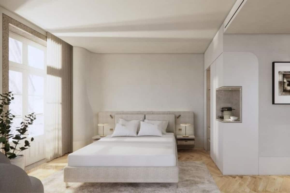 Ein modernes Schlafzimmer mit einem großen Bett, Nachttischen, einem Einbauschrank und einer kleinen Küchenzeile.
