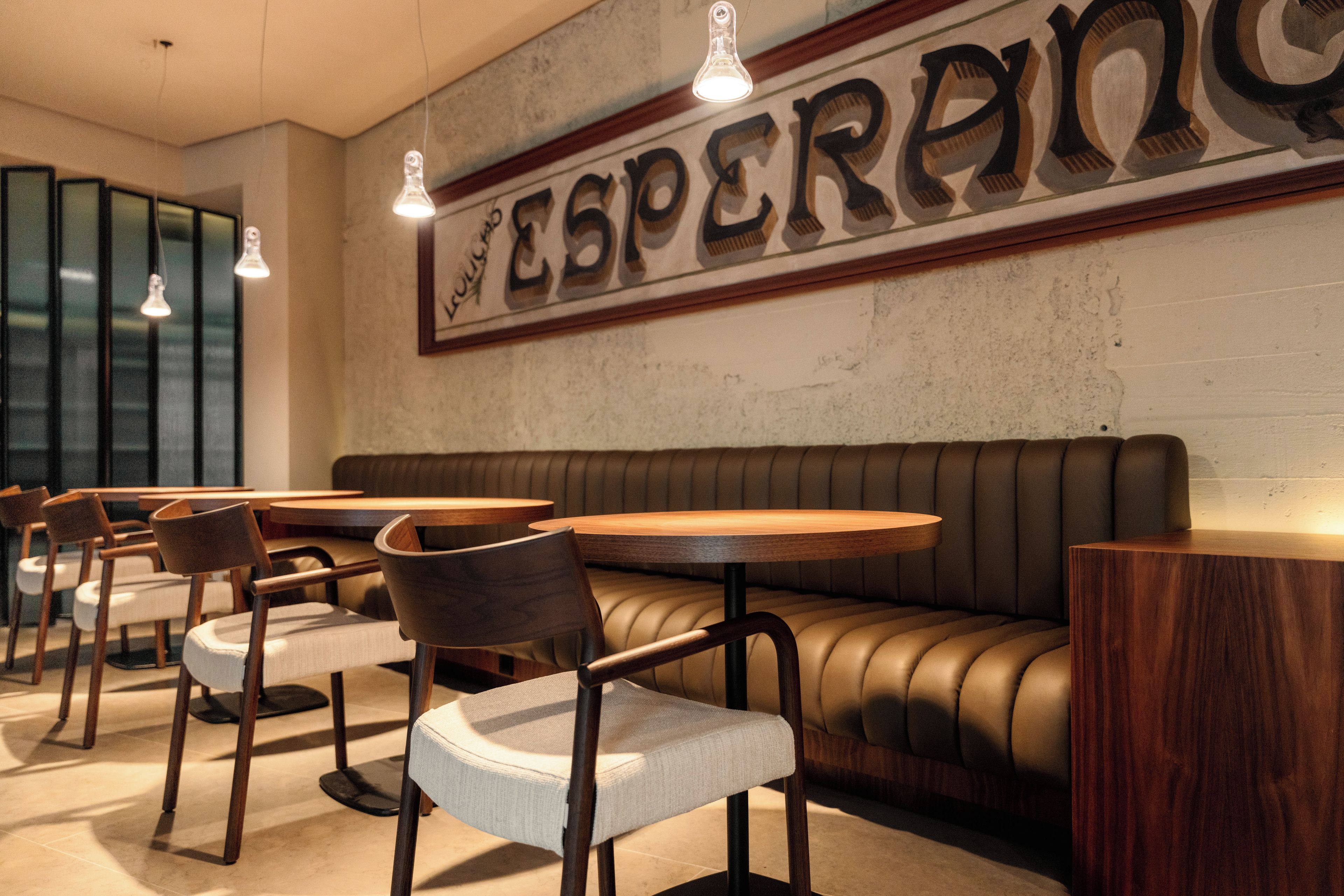 Un interior de restaurante con cabinas, mesas y sillas.