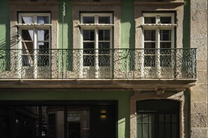 A building with a green facade, multiple windows, and a balcony with ornate metal railings. - Esperanca Hotel Braga Vignette Collection By Ihg (Braga)