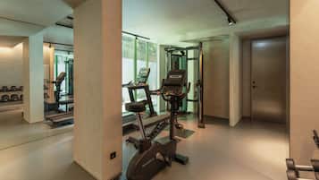 Ein modernes Fitnessstudio mit Laufbändern, Hanteln und einer Spiegelwand.