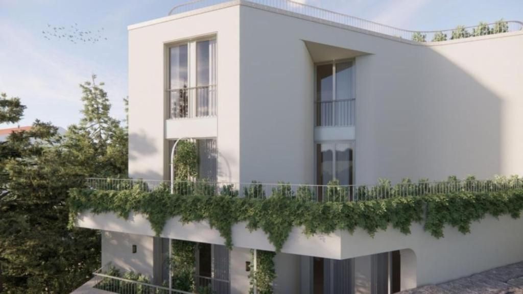 A modern building with a flat roof, large windows, and a balcony with greenery.