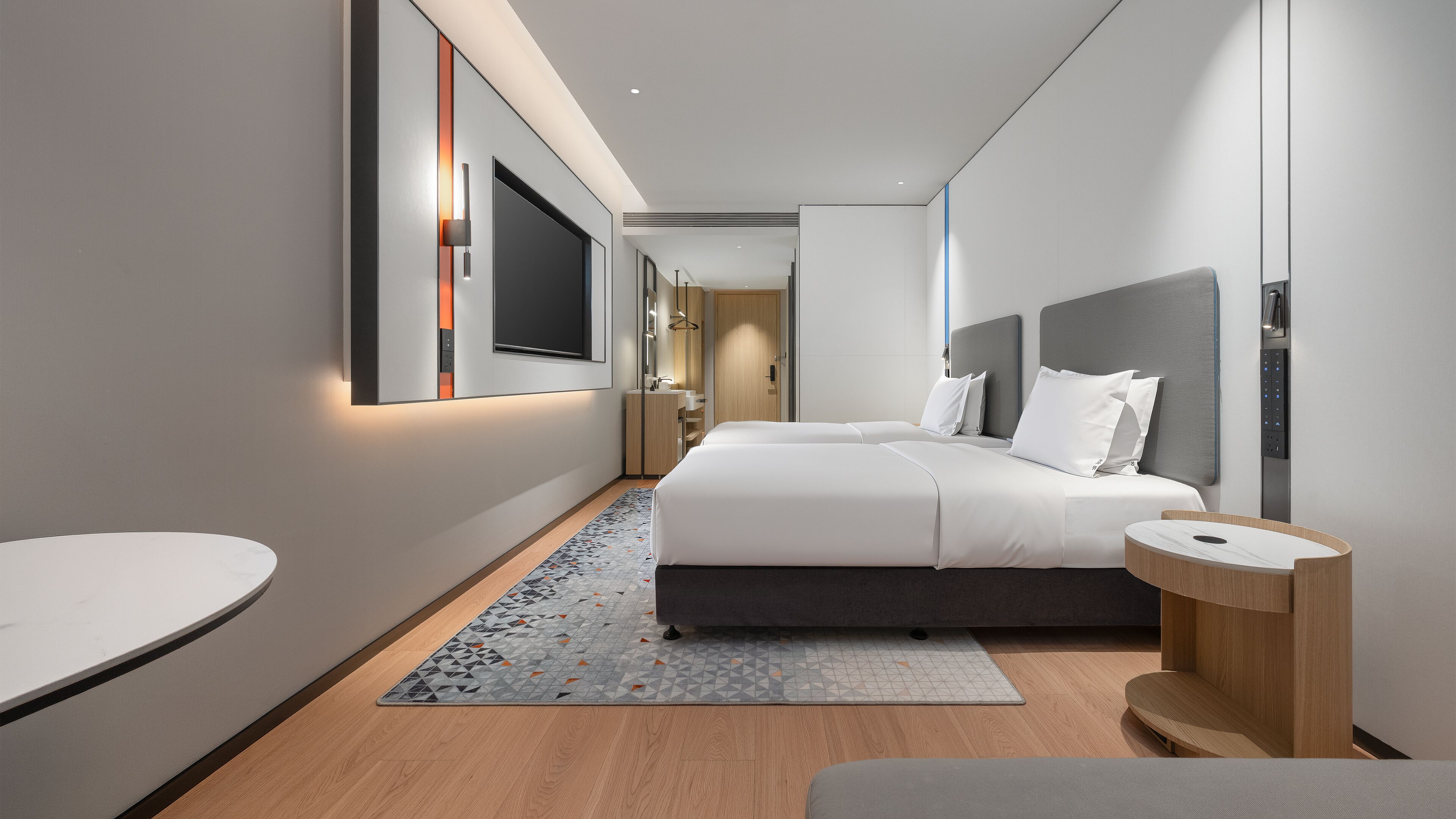 A modern hotel room with a large bed, bedside tables, a desk, and a bathroom.