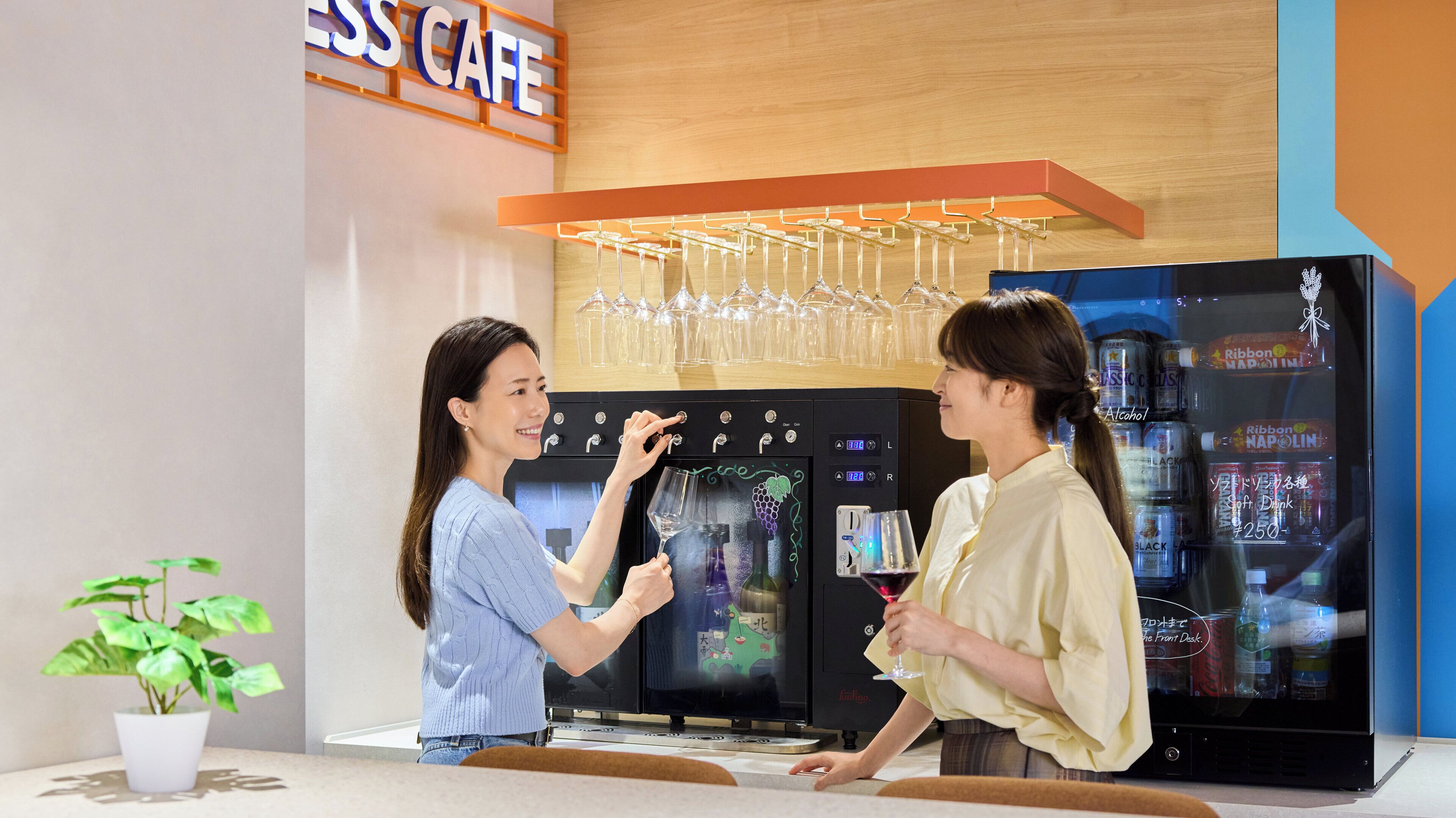 Una cafetería con dispensador de vino y un refrigerador lleno de bebidas.