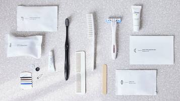A variety of grooming and personal care items laid out on a textured surface.