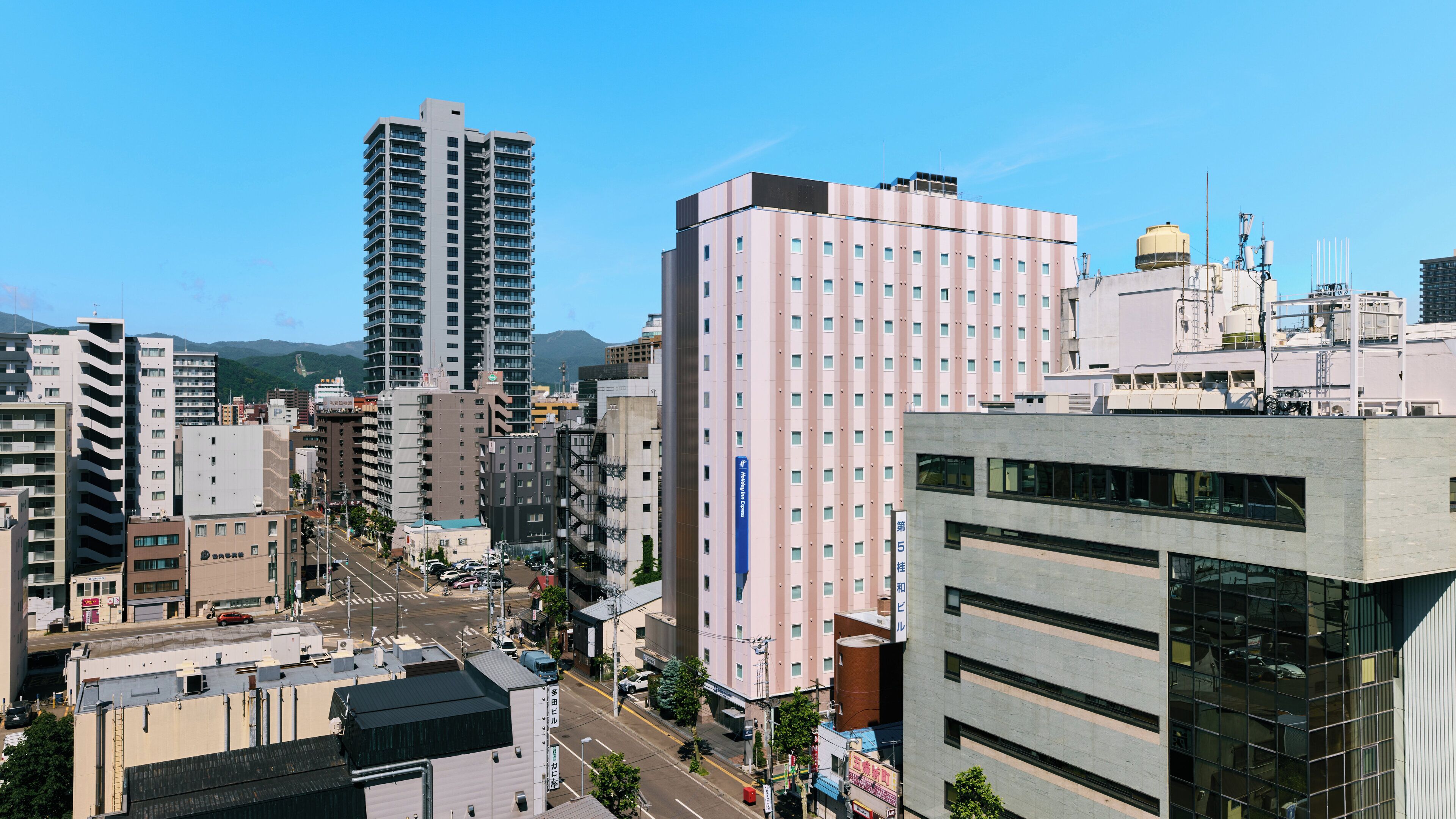 Vista urbana con edificios modernos, incluyendo un hotel con un letrero llamativo.