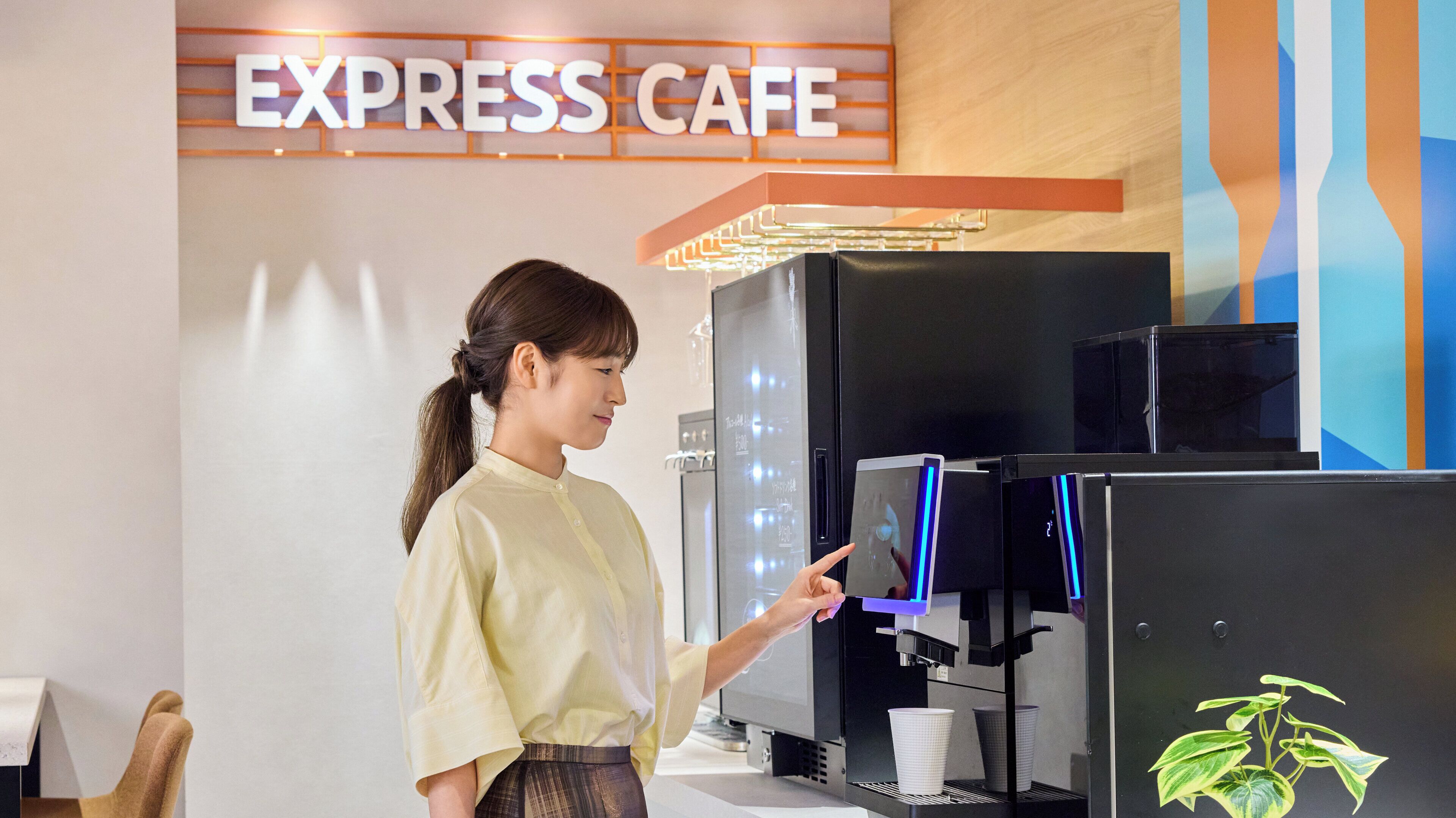 A person interacting with a coffee machine in a cafe setting.