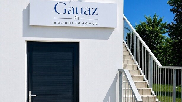 A building with a sign reading 'Gauaz Boardinghouse' and a black door. - Gauaz Boardinghouse  (Maisach)