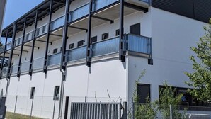 A multi-story building with balconies, a flat roof, and a white facade. - Gauaz Boardinghouse  (Maisach)