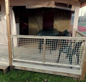 Une structure en bois dotée d’une enceinte en treillis métallique, d’un banc et d’un espace abrité.