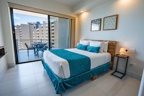 Ein Hotelzimmer mit Bett, Nachttisch, Lampe und Blick ins Freie.