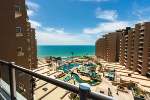 A resort with multiple swimming pools, a beach, and high-rise buildings.