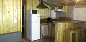 Une cuisine compacte équipée d’un réfrigérateur, d’un four à micro-ondes et d’une cuisinière.