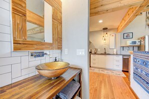Ein modernes Badezimmer mit einem Holzbadezimmermöbel, einem großen Spiegel und einem Waschbecken.