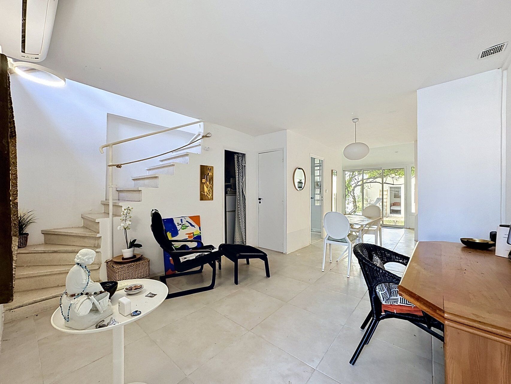 Un espace de vie moderne comprenant un escalier, un coin repas et une cuisine.