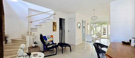 Un espace de vie moderne comprenant un escalier, un coin repas et une cuisine.