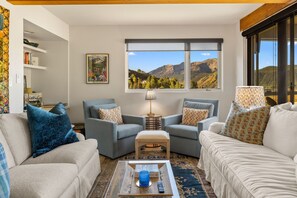 Ein Wohnzimmer mit zwei Sofas, einem Couchtisch und einem Bücherregal.