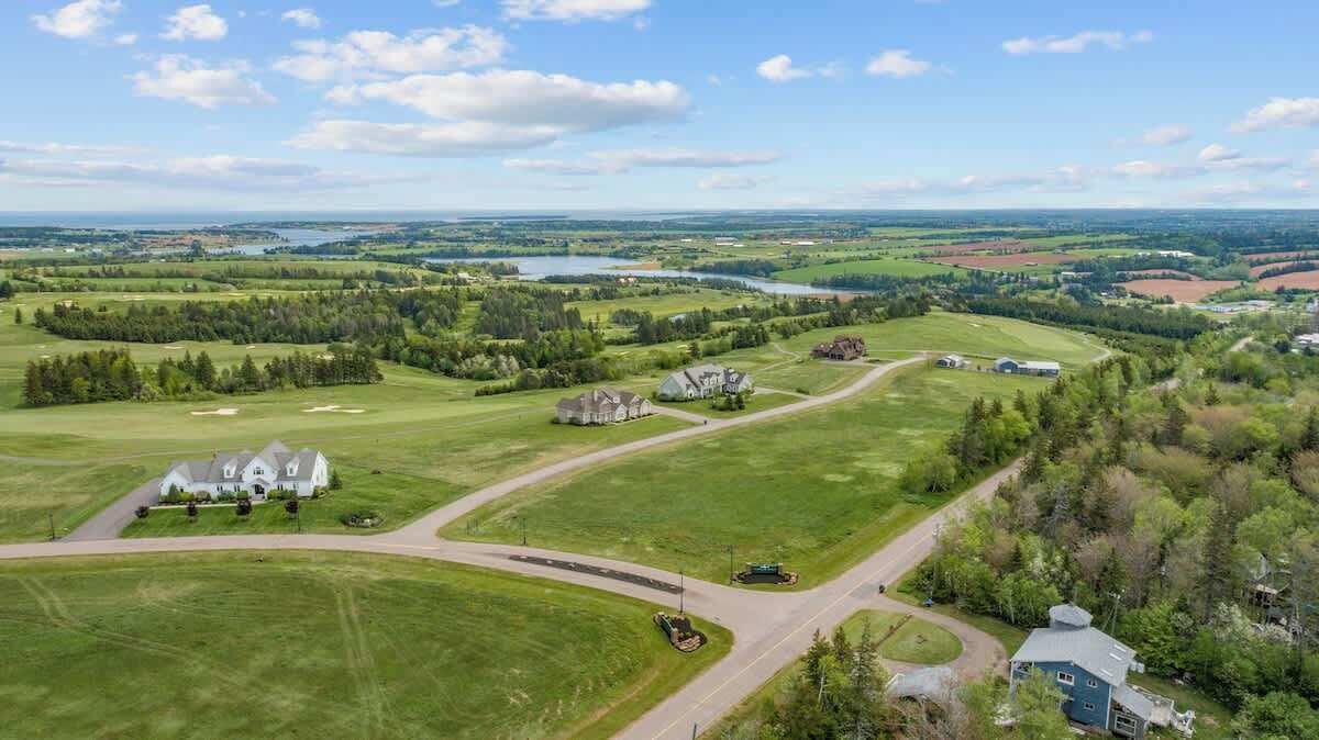Vista aérea de un paisaje rural con una casa grande, un edificio más pequeño y una carretera.