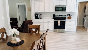 Una cocina moderna con armarios blancos, microondas y estufa.