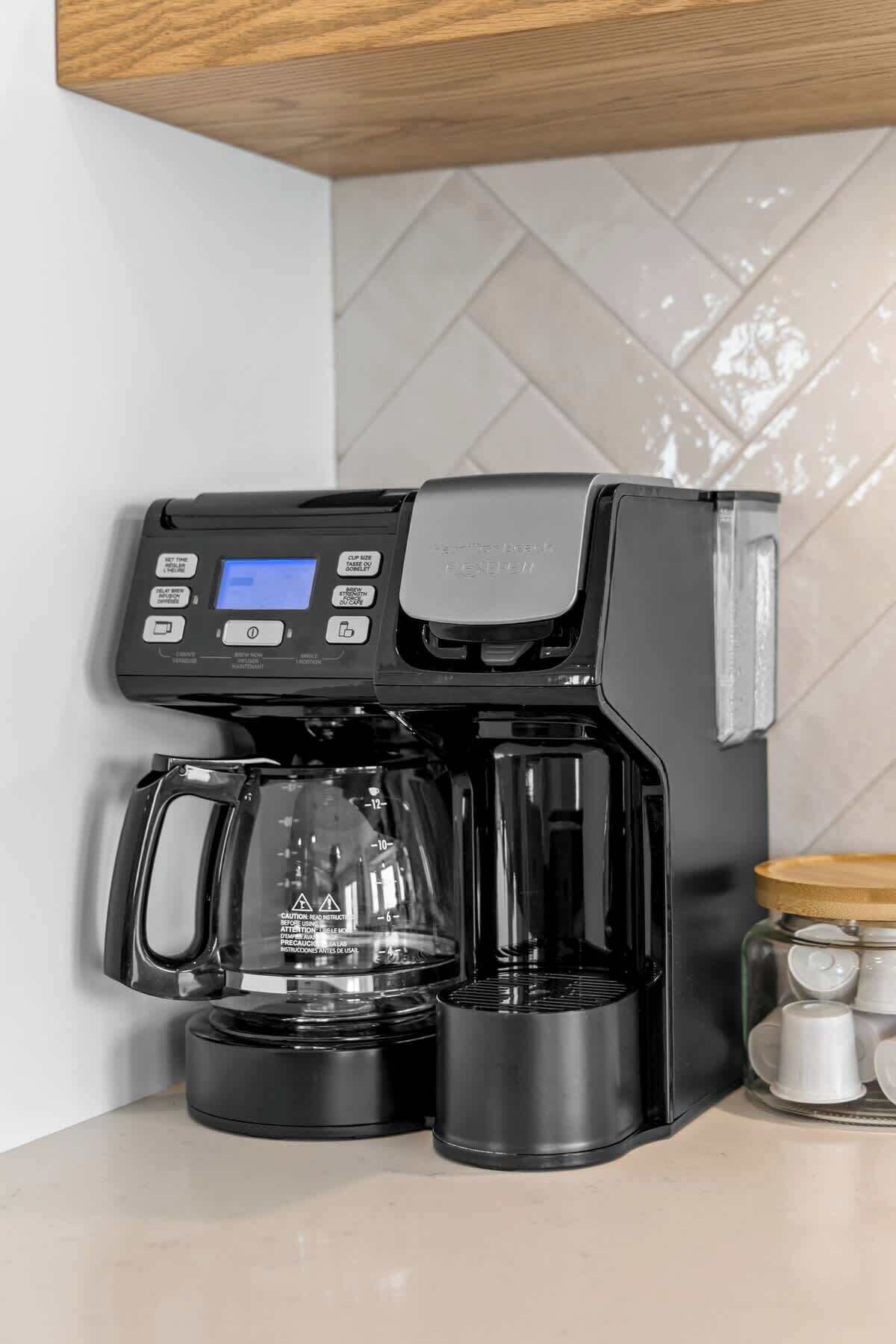 Una cafetera con pantalla digital, jarra de vidrio y bandeja de goteo.
