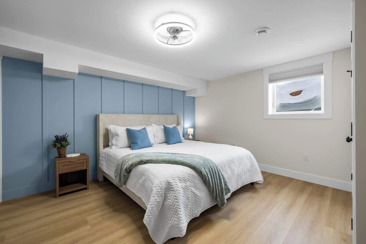 Une chambre à coucher avec un lit, une table de chevet et une fenêtre donnant sur un beau paysage.