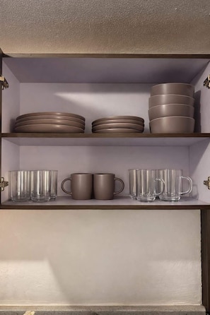 Ein Schrank mit Regalen, gefüllt mit Tellern und Tassen.