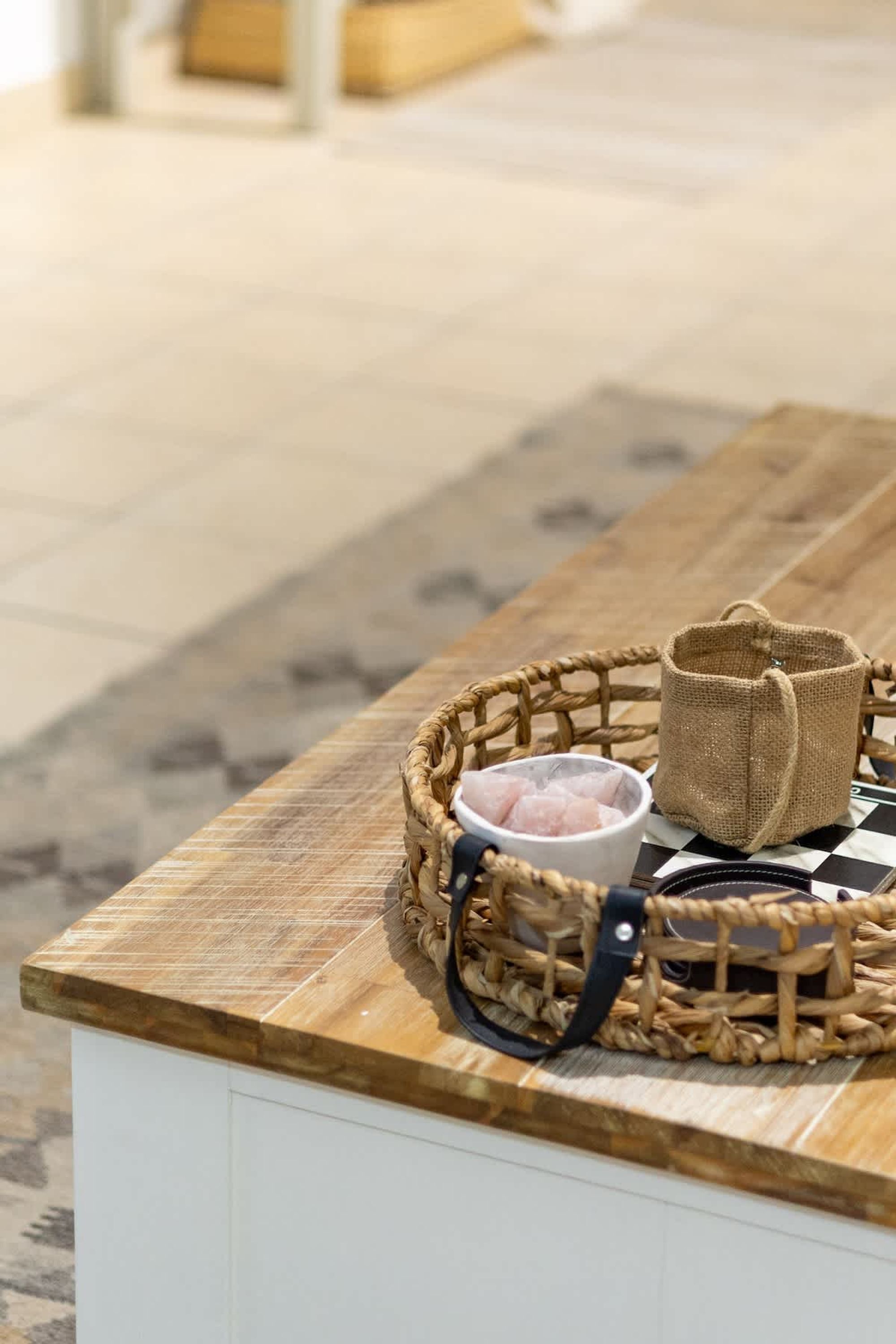 Una mesa de madera con una cesta tejida que contiene un tazón pequeño y una bolsa de tela.