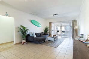 Una sala de estar moderna con un sofá, una mesa de centro y plantas en macetas.