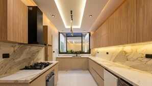 A modern kitchen with a central island, built-in oven, and a dishwasher. - Spacious 3 Bedroom Apartment in Tangier - Near Stadium, Airport and Beaches (Tanger)