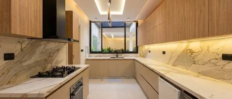 A modern kitchen with a central island, built-in oven, and a dishwasher.