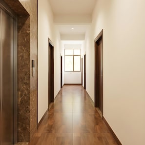 Un long couloir étroit, doté d’un plancher en bois et de portes des deux côtés.