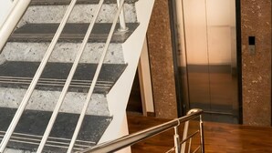 A staircase with metal railings leading to an elevator.