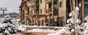 A multi-story building with balconies, a stone facade, and a covered outdoor area. - Spacious 2-bedroom condo in beautiful Park City with fire place and gym (Park City)