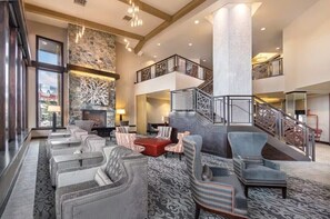 A spacious lobby with a fireplace, seating area, and a staircase leading to an upper level. - Spacious 2-bedroom condo in beautiful Park City with fire place and gym (Park City)