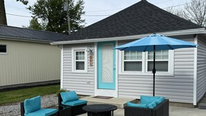 Une maison avec une porte bleue, une véranda avec des meubles d’extérieur et une boîte aux lettres.