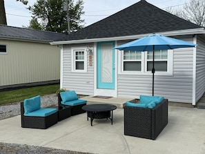 A house with a blue door, a porch with outdoor furniture, and a mailbox.