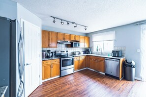 A kitchen with wooden cabinets, stainless steel appliances, and a window.
