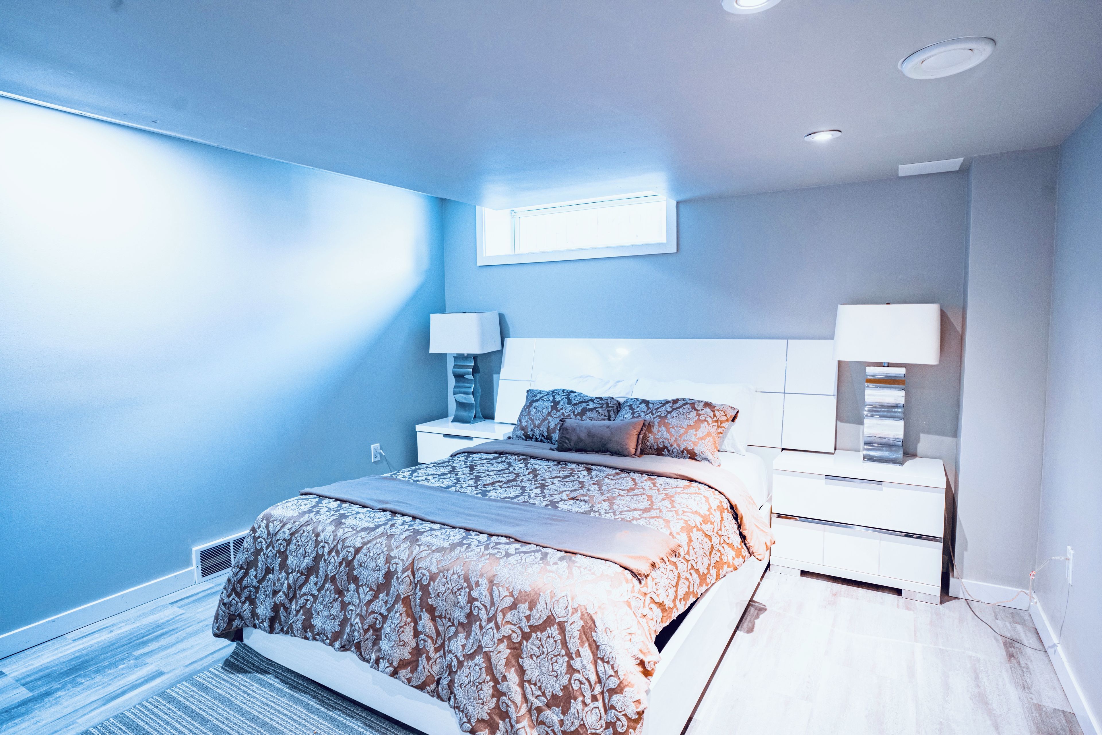Ein Schlafzimmer mit einem Bett, Nachttischen und einem Fenster.